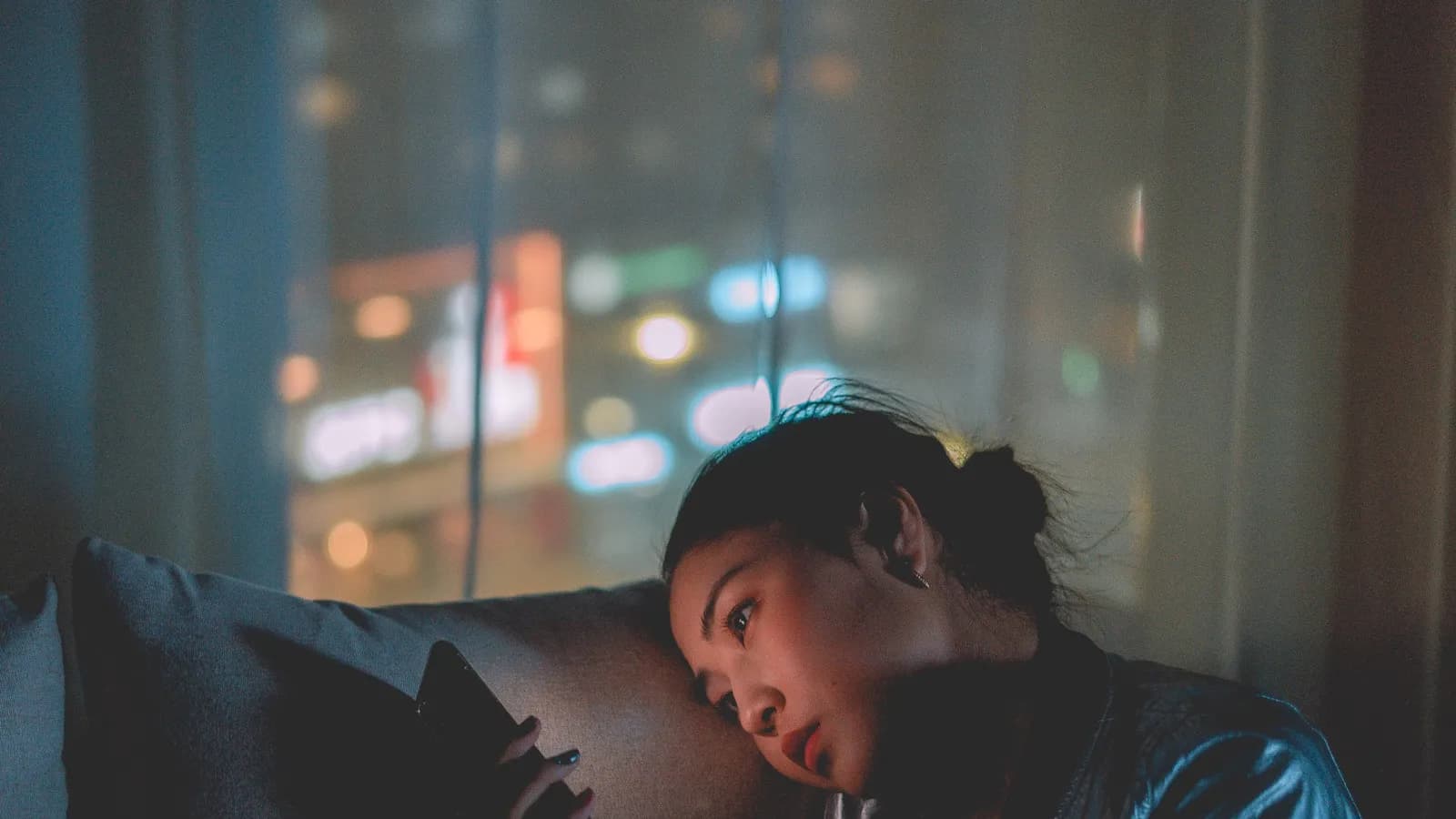 Người mệt mỏi tựa đầu nhìn màn hình điện thoại