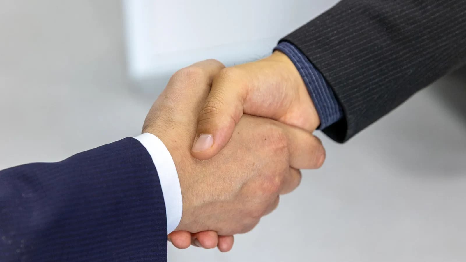 Hai doanh nhân bắt tay sau buổi làm việc — quan hệ khách hàng B2B