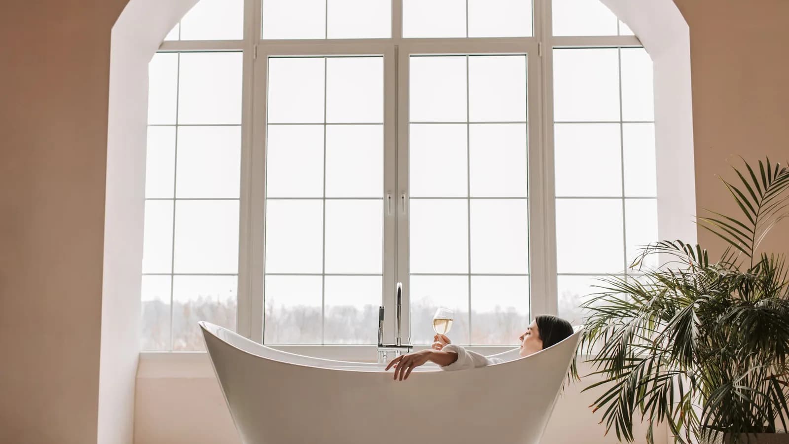Phòng thư giãn sáng sủa với bồn tắm và cây xanh — không gian spa