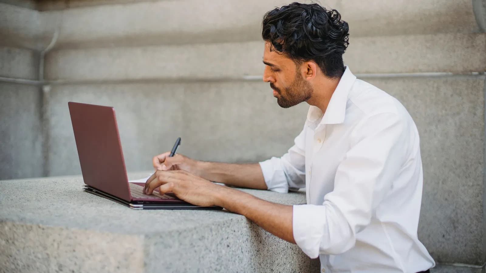 Người làm việc trên laptop bên bàn ngoài trời — doanh nghiệp phần mềm