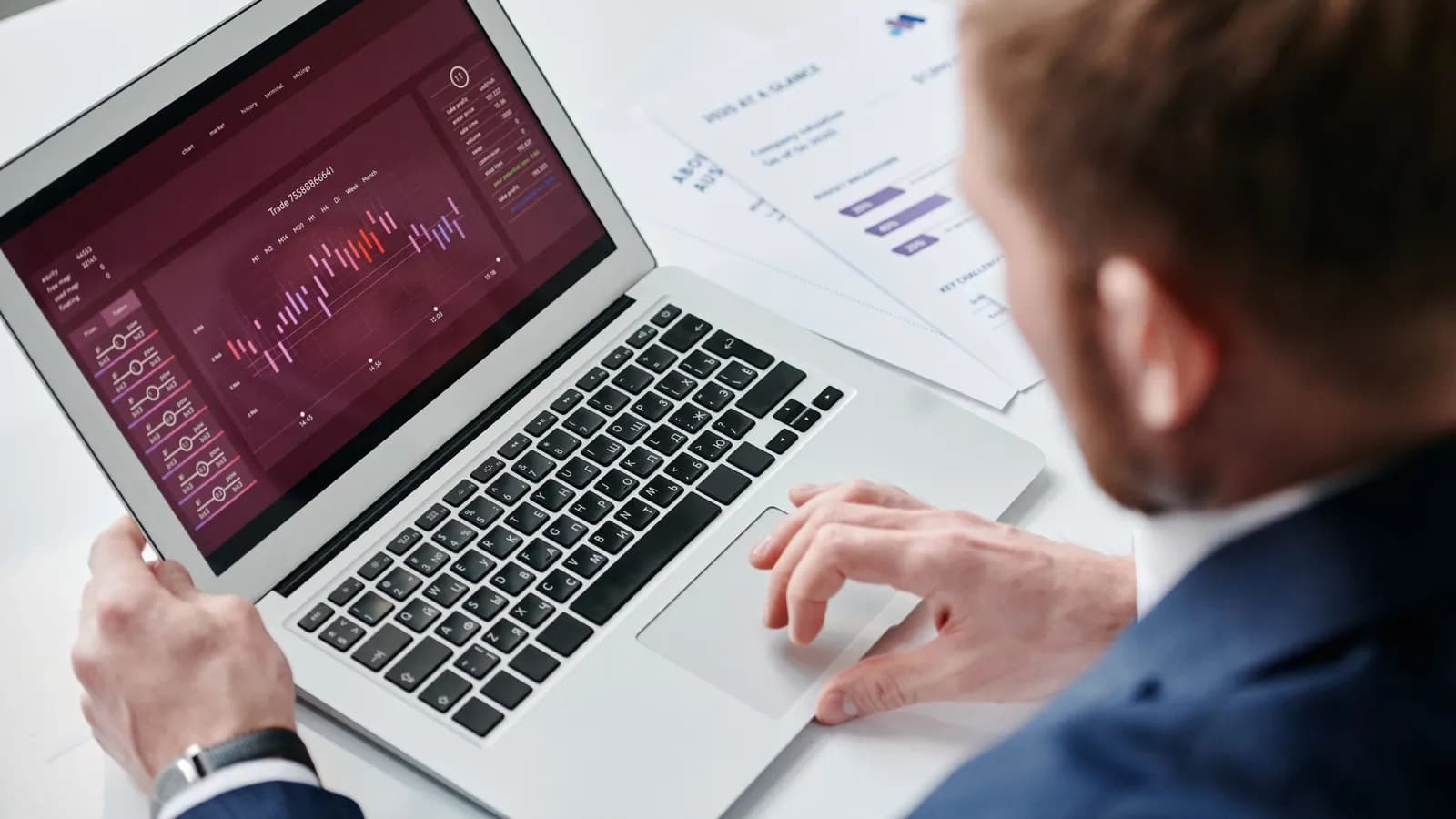 Người đàn ông xem bảng số liệu phân tích trên laptop