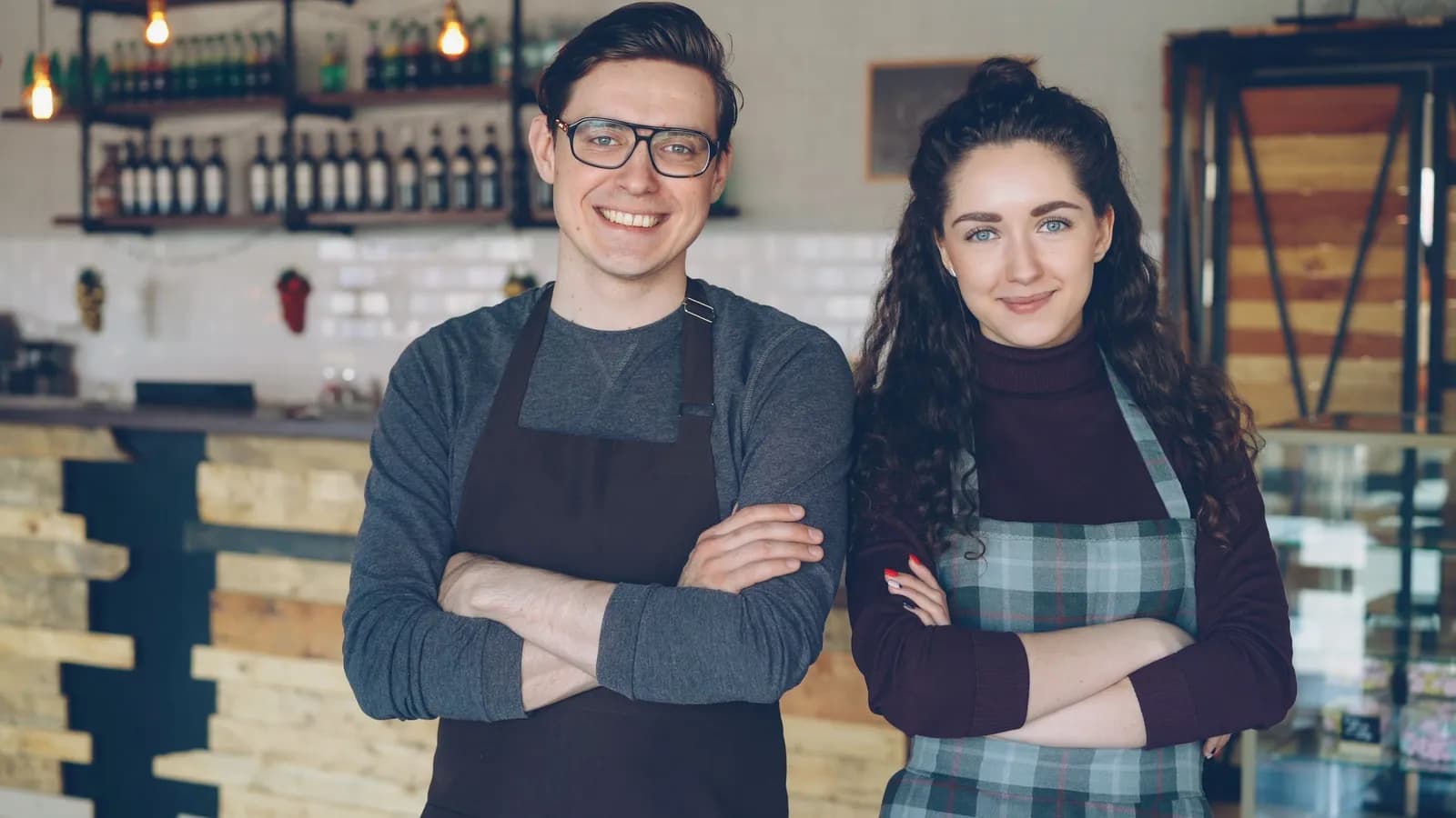 Hai chủ quán cà phê nhỏ đứng trước quầy — mô hình doanh nghiệp nhỏ tự làm marketing