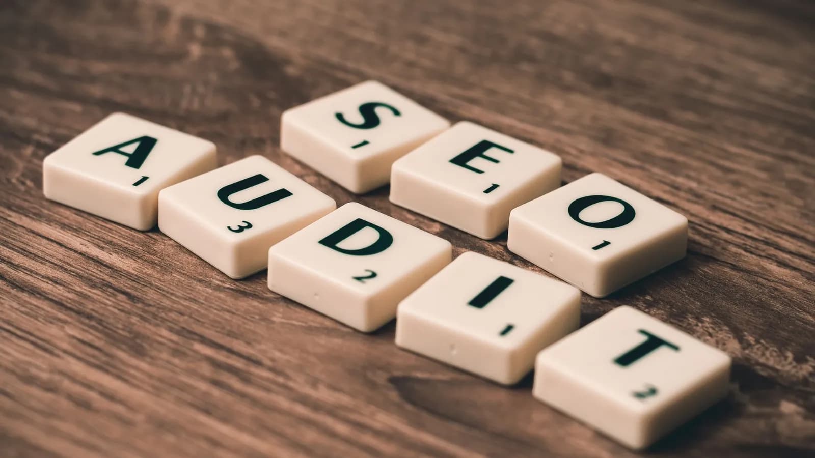 Các miếng chữ gỗ ghép thành dòng chữ SEO AUDIT trên mặt bàn
