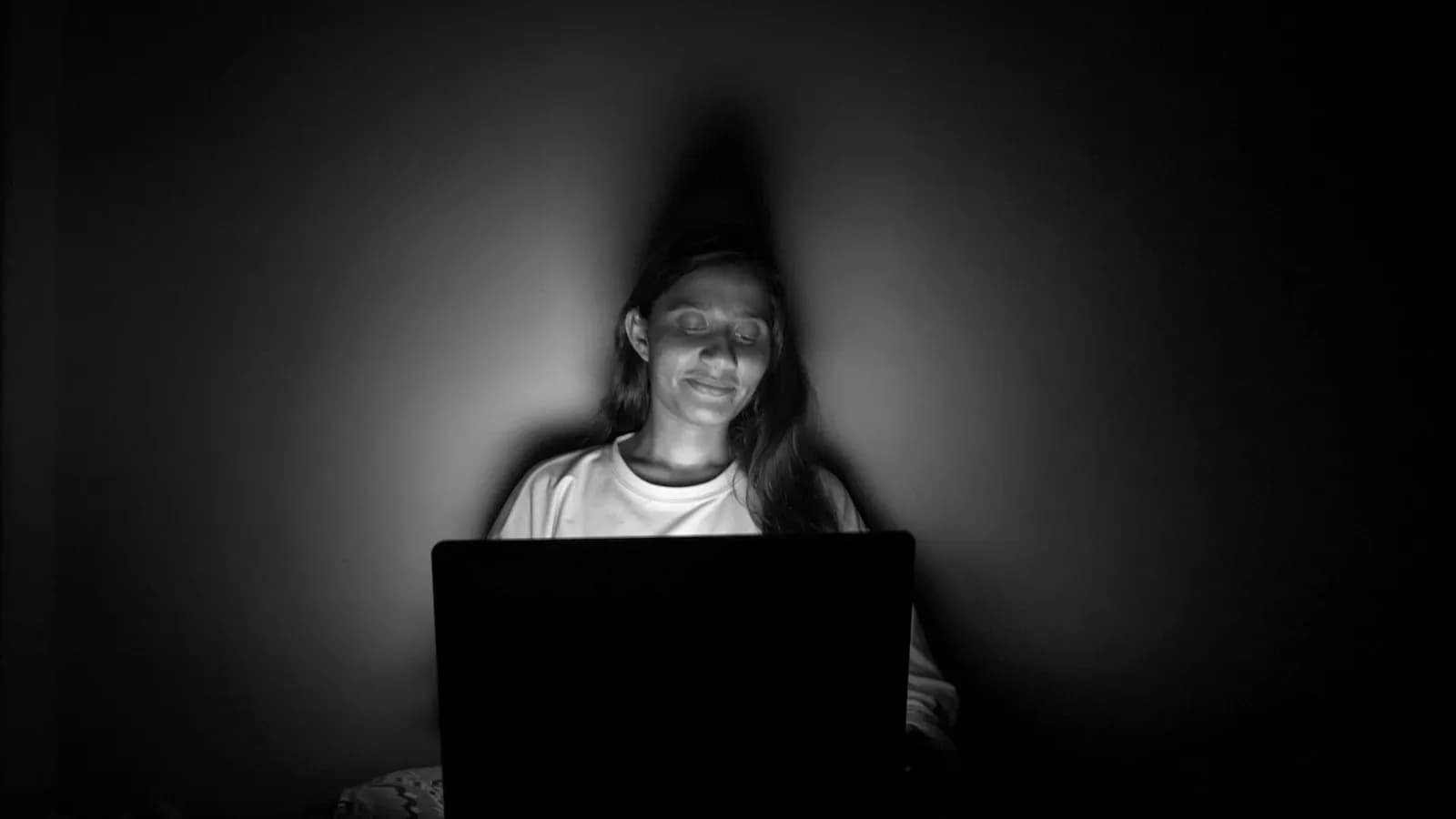 Người dùng laptop trong phòng tối, chỉ có ánh sáng màn hình